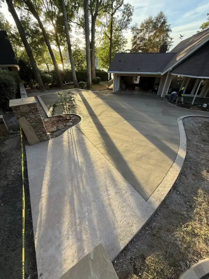 A large textured concrete patio and courtyard area photographed in warm low-angle sunlight.