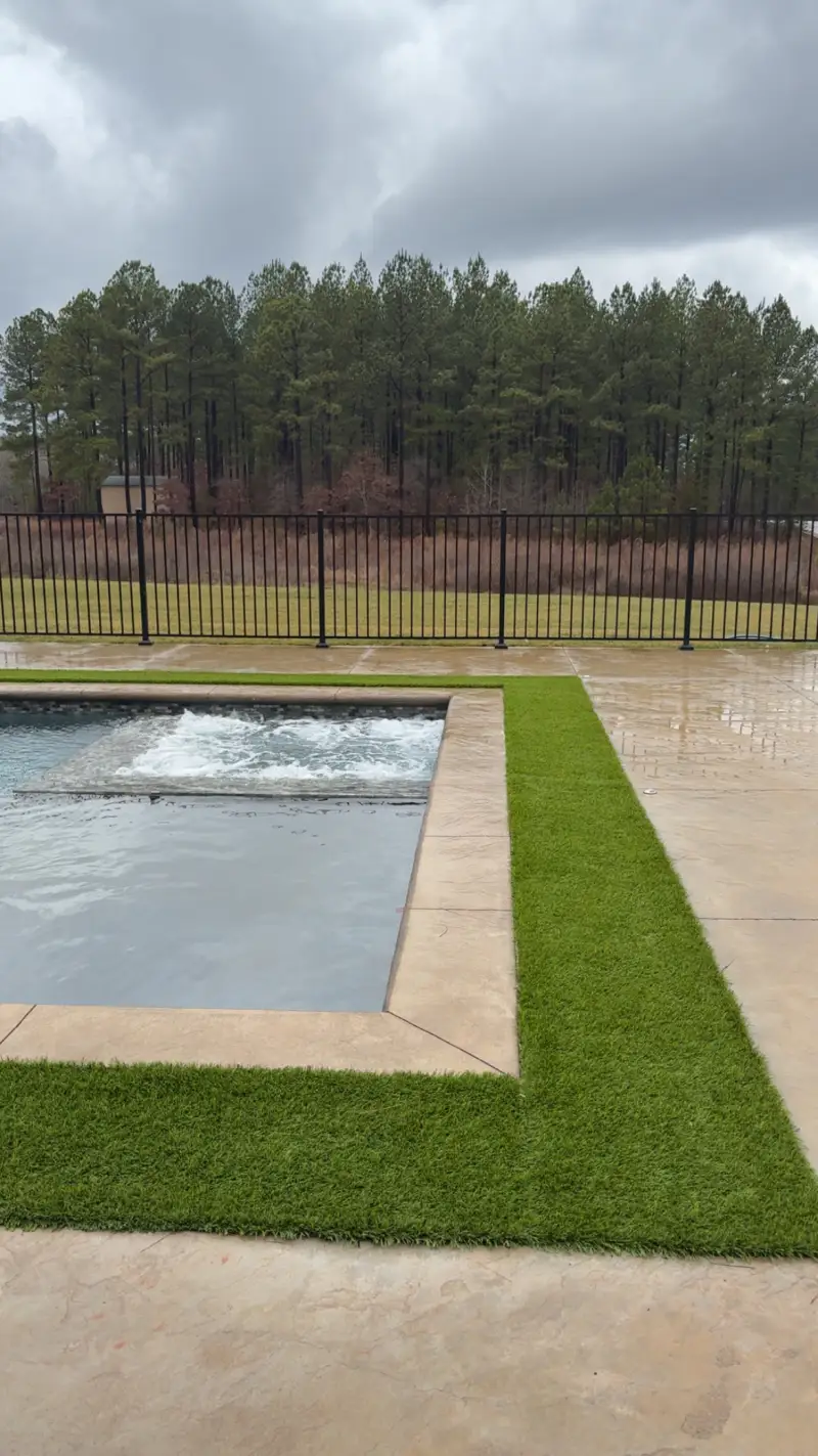 A stamped and coloured concrete pool deck surrounding an in-ground swimming pool.
